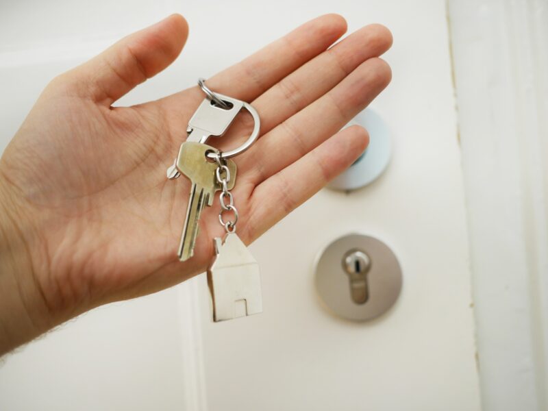 hand, holding a bunch of keys in front of a door