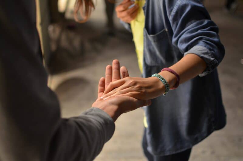 a volunteer holding their hand out to help another person