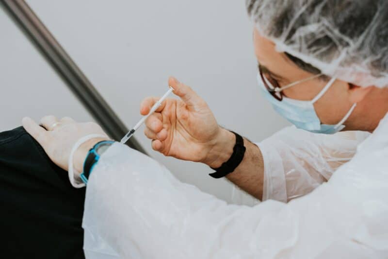 a nurse injecting a shoulder