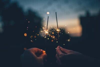 two people holding sparklers in the dark