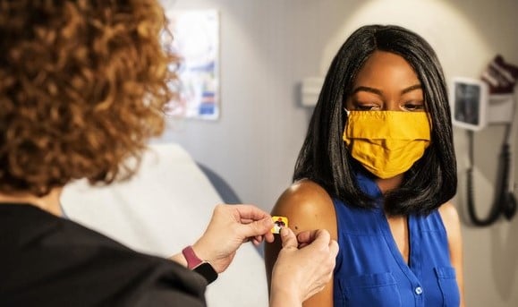 A lady receiving her vaccination into her upper arm