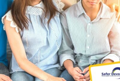 mother and son sitting by each other. Mother has arm around her son's shoulder