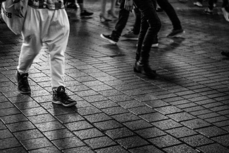 Young men walking. Photograph focuses on their legs and feet.