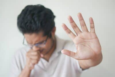A man coughing into his hand
