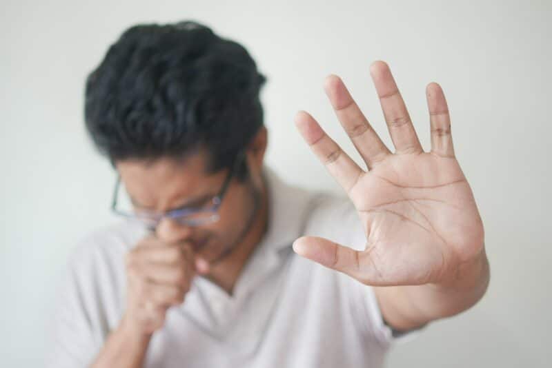 A man coughing into his hand