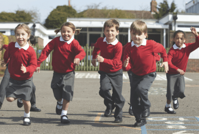 Primary school age children running across a playground