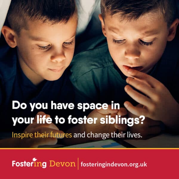 Two brothers reading a single book in a tent