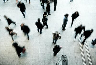 A photo taken from above, of a crowd of people walking outside in an urban area