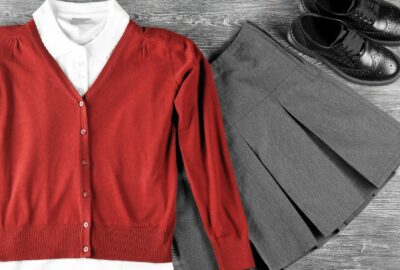 A red school jumper, white t-shirt with collar, and grey school skirt