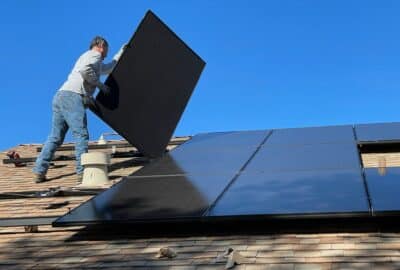 A man fitting solar panels to a roof