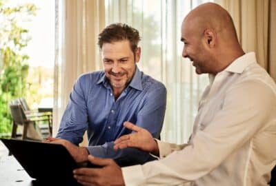 Two professional people looking at a laptop computer