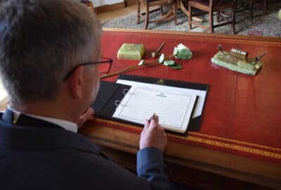 Chairman of Devon County Council, Cllr Ian Hall, signing the Book of Condolence
