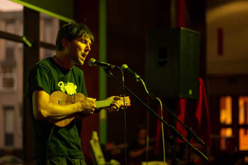 A musician, singing and playing guitar