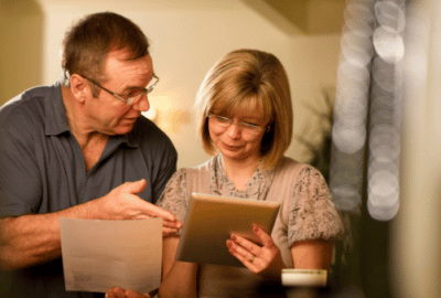 A couple looking closely at a bill in the post