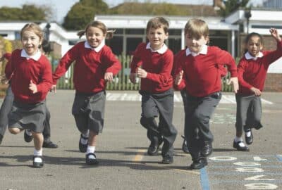 Primary school age children running across a playground