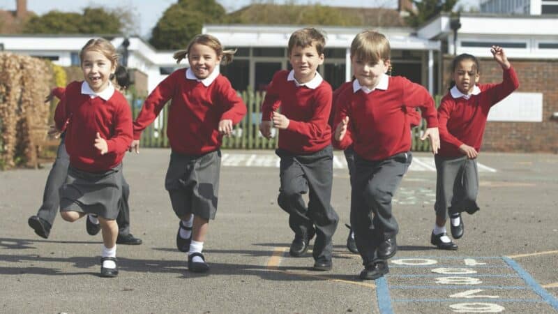 Primary school age children running across a playground