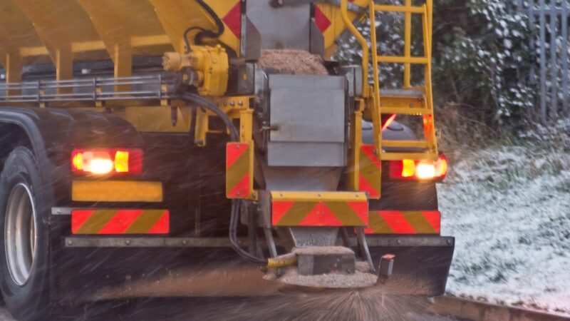 A gritting lorry spreading grit