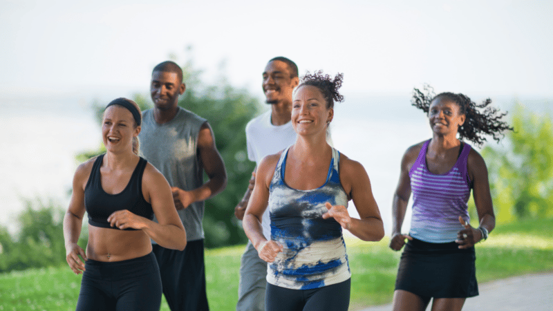 A group of people out jogging in a park