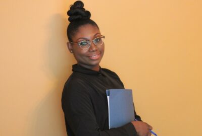 Women smiling at the camera holding a folder