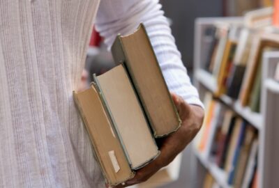 A person carrying an armful of books