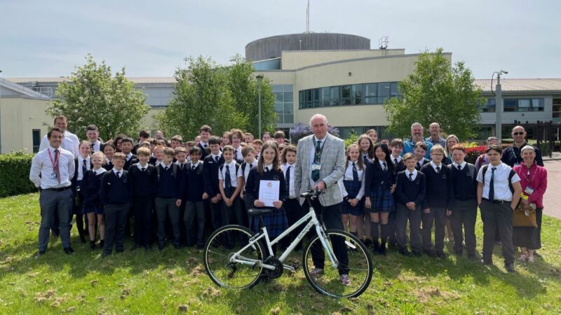 Beatrice Stothert, the 100,000th Bikeability trainee in Devon receives a bike and certificate from Councillor Stuart Hughes