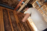 Lady insulating a wall