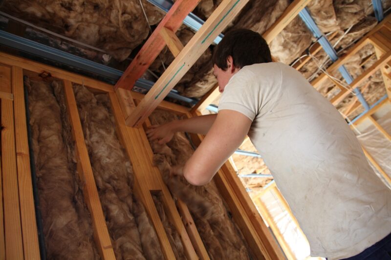 Lady insulating a wall