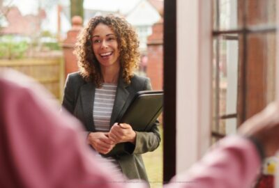 A social worker talking to a young person at the door of their house