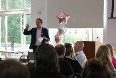 Manager of T-Smart and REACH team services, speaking to a room of people.