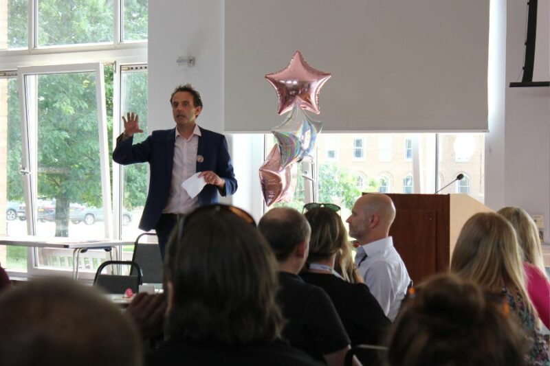 Manager of T-Smart and REACH team services, speaking to a room of people.