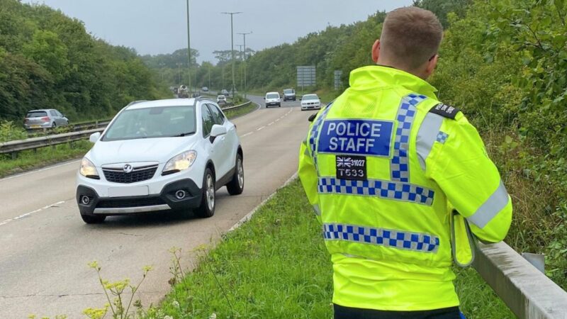 Police officer using speed detection equipment
