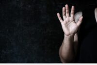 A woman holding up her hand, palm outstretched