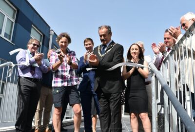 The Chairman of Devon County Council, with VIPs and guests attending, officially cuts a ribbon to open the new school building