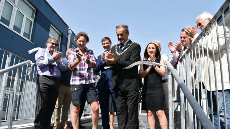 The Chairman of Devon County Council, with VIPs and guests attending, officially cuts a ribbon to open the new school building