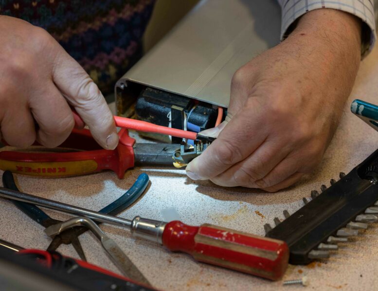 Hands fixing electrical equipment