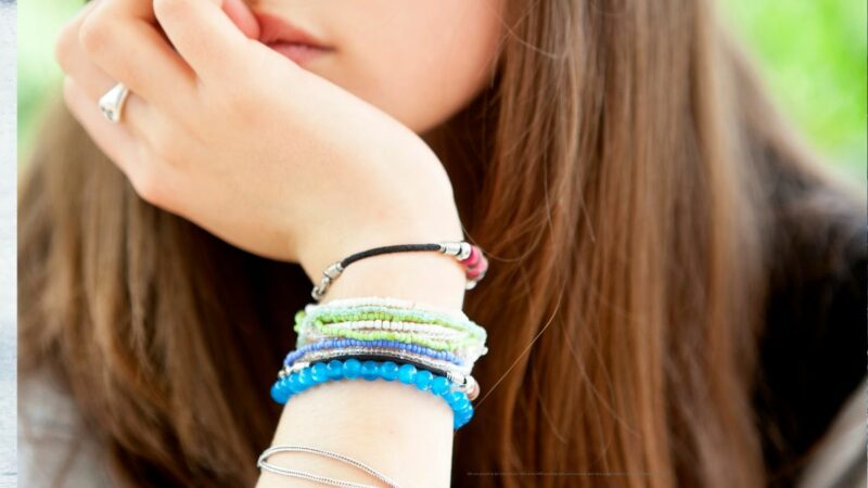 Close up photo of a teenage girl. Only her hand on her chin is in view