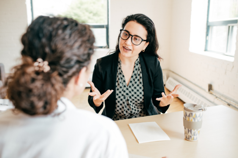 Woman talking to another woman across a desk