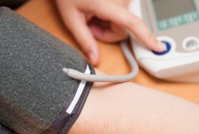 A person checking their own blood pressure using a monitor