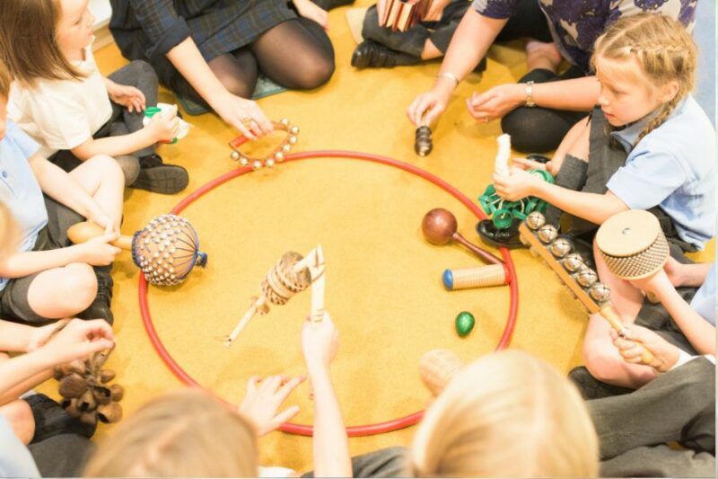 A group of primary school age children sat in a circle playing