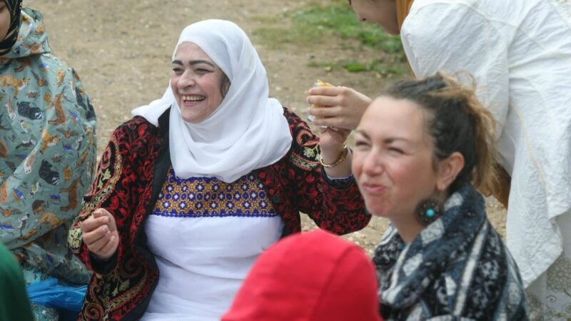 A group of women sat together smiling and laughing