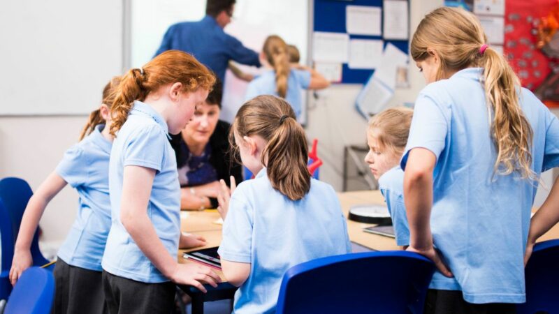 A group of Primary School pupils sat around a desk working together