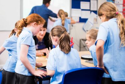 A group of Primary School pupils sat around a large desk working together