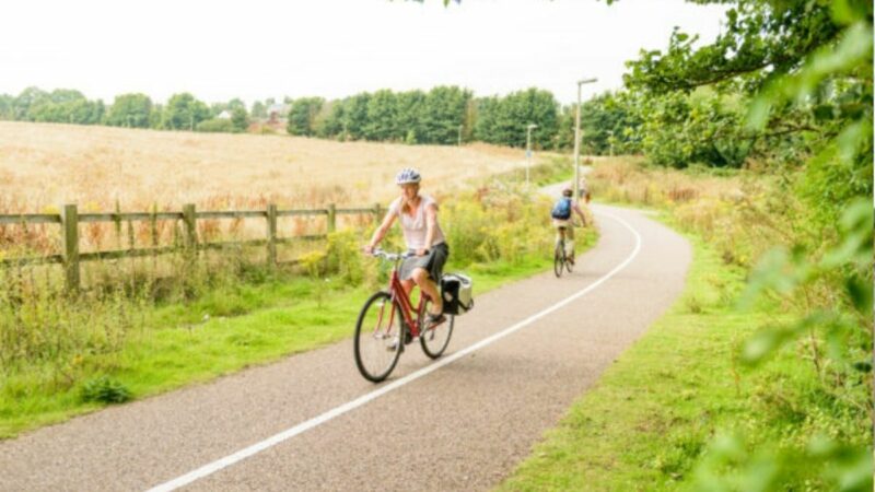 Two cyclists cycling along a cycle path