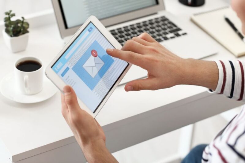 Hands on an ipad opening an email