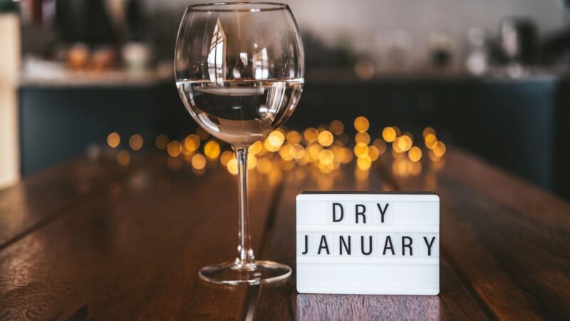 A wine glass containing water or lemonade, and a sign reading 'dry january'