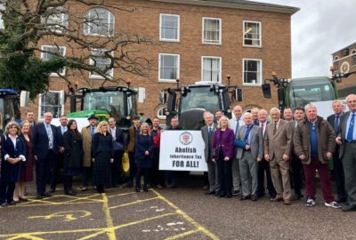 Tractors parked in the car park at County Hall, Exeter with Councillors stood in front of the tractors