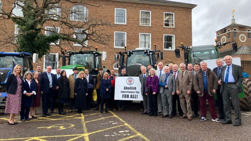 Tractors parked in the car park at County Hall, Exeter with Councillors stood in front of the tractors