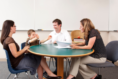Family sat around a table talking to a professional