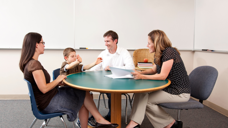 Family sat around a table talking to a professional