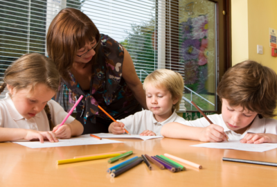 Children in a small group writing with a teacher